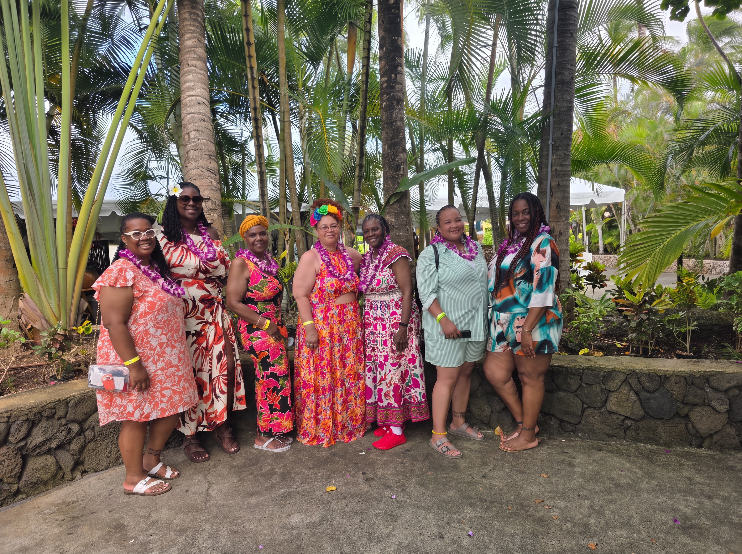 Roseway travelers wearing leis under palm trees on an island getaway
